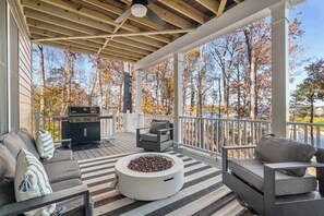 Une terrasse extérieure couverte, équipée d’un barbecue, de sièges et d’un foyer.