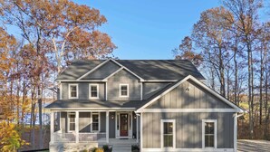 A two-story house with a front porch, stone foundation, and a number '390' on the right side. - Lakefront Lake Anna - Decks, Views, Hot Tub (Louisa County)