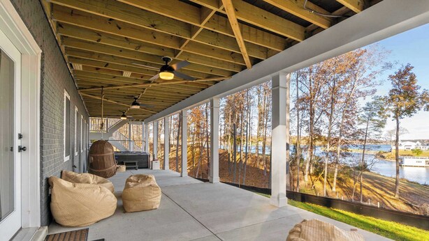 A covered porch with a view of a lake, large bean bags, and a ceiling fan. - Lakefront Lake Anna - Decks, Views, Hot Tub (Louisa County)