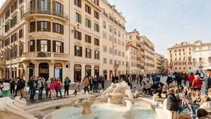 A public square with a fountain and people gathered around. - The Couper Piazza di Spagna (Rome)