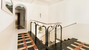 A modern hotel lobby with a marble staircase, a glass railing, and a minimalist design. - The Couper Piazza di Spagna (Rome)