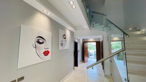 A modern interior with a staircase, a hallway with artwork, and a view to the outside. - فيلا للايجار اليومي خمس غرف داخل كمبوند بالم هيلز
villa for daily rent (Giza Governorate)