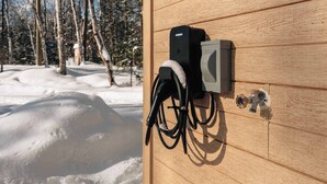 Un mur en bois équipé d’une station de recharge et d’un petit haut-parleur fixé sur celui-ci.