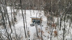 Une cabane entourée d’arbres couverts de neige.