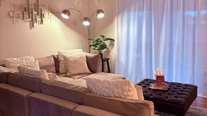 Una sala de estar moderna con un sofá seccional, una mesita auxiliar y un elemento decorativo en la pared.