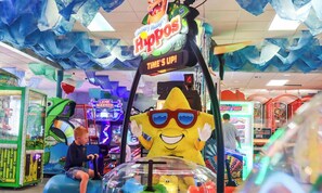 An arcade with various games and a large inflatable character.