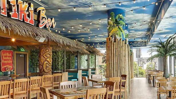 A restaurant with a tropical theme, featuring wooden furniture and a mural of a palm tree on the ceiling. - Walk to the 2026 FIFA games! (Atlanta)