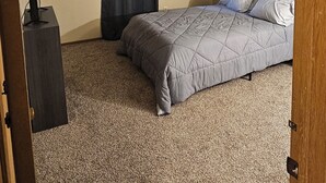A bedroom with a bed, a dresser, a curtain, and a ceiling with a textured pattern. - 3-bedroom house in lancaster. (Lancaster)