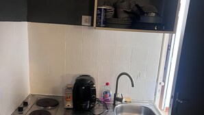 A compact kitchen with a stove, sink, and a small countertop area.
