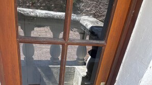 A wooden door with glass panels, a metal handle, and a welcome mat.