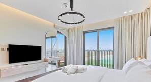 Une chambre d’hôtel moderne dotée d’un grand lit, d’une télévision à écran plat, d’un balcon offrant une vue sur la ville et d’un luminaire au plafond au design circulaire unique.