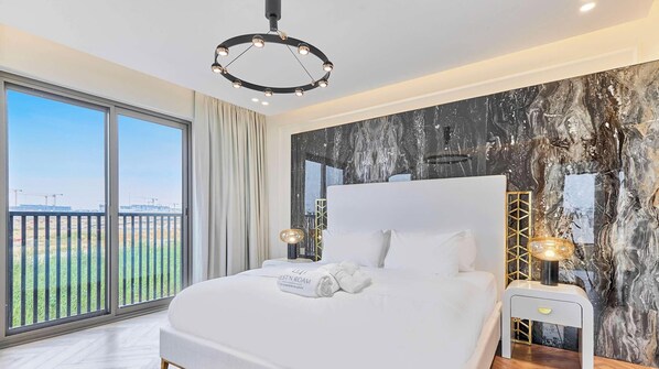 Une chambre d’hôtel avec un grand lit, une vue sur un chantier de construction et un lustre moderne.