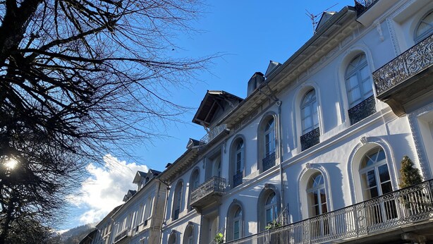 Un edificio a più piani con balconi decorati e finestre ad arco.
