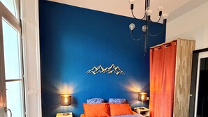 Una camera da letto con un letto, due comodini, un lampadario e un’applique.