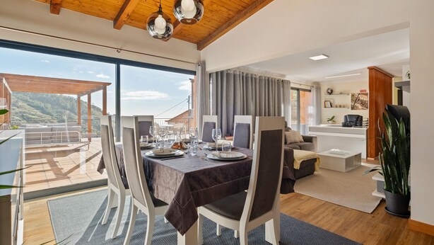 A dining area with a table set for six, large windows, and a view of the outdoors. - Quinta do Checa by Homie (Quinta Grande)