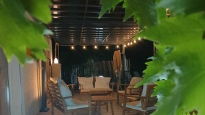 Un espace extérieur aménagé avec du mobilier en bois et des guirlandes lumineuses.