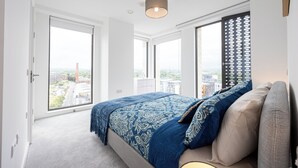 Ein Schlafzimmer mit einem großen Bett, einem Fenster mit Blick und einer Deckenleuchte.