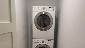 Una sala de lavandería con dos lavadoras apiladas.