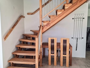A wooden staircase with a handrail, a wall-mounted radiator, and two wooden chairs. - 5 Star Holiday Home in Falkenberg (Falkenberg)