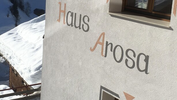 Un bâtiment dont la façade porte l’inscription « Haus Arosa ».