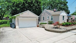 A residential area with two houses, each with a garage, surrounded by trees and a well-maintained lawn. - South Jersey Shore Comfort & Relaxing  Retreat in Absecon, near  Atlantic City (Absecon)