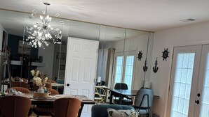 A modern living room with a dining area, a ceiling fan, and a large window with a view. - South Jersey Shore Comfort & Relaxing  Retreat in Absecon, near  Atlantic City (Absecon)