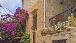 A stone building with a balcony, potted plants, and a bicycle. - Villa for 8 Guests With Gorgeous View (Kissamos)