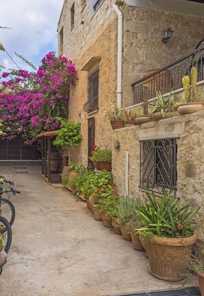 A stone building with a balcony, potted plants, and a bicycle. - Villa for 8 Guests With Gorgeous View (Kissamos)