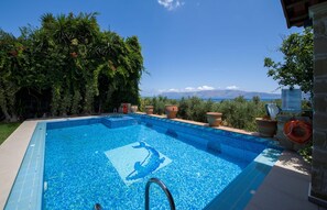 A rectangular swimming pool with a clear blue mosaic pattern, surrounded by terracotta pots and lush greenery. - Villa for 8 Guests With Gorgeous View (Kissamos)