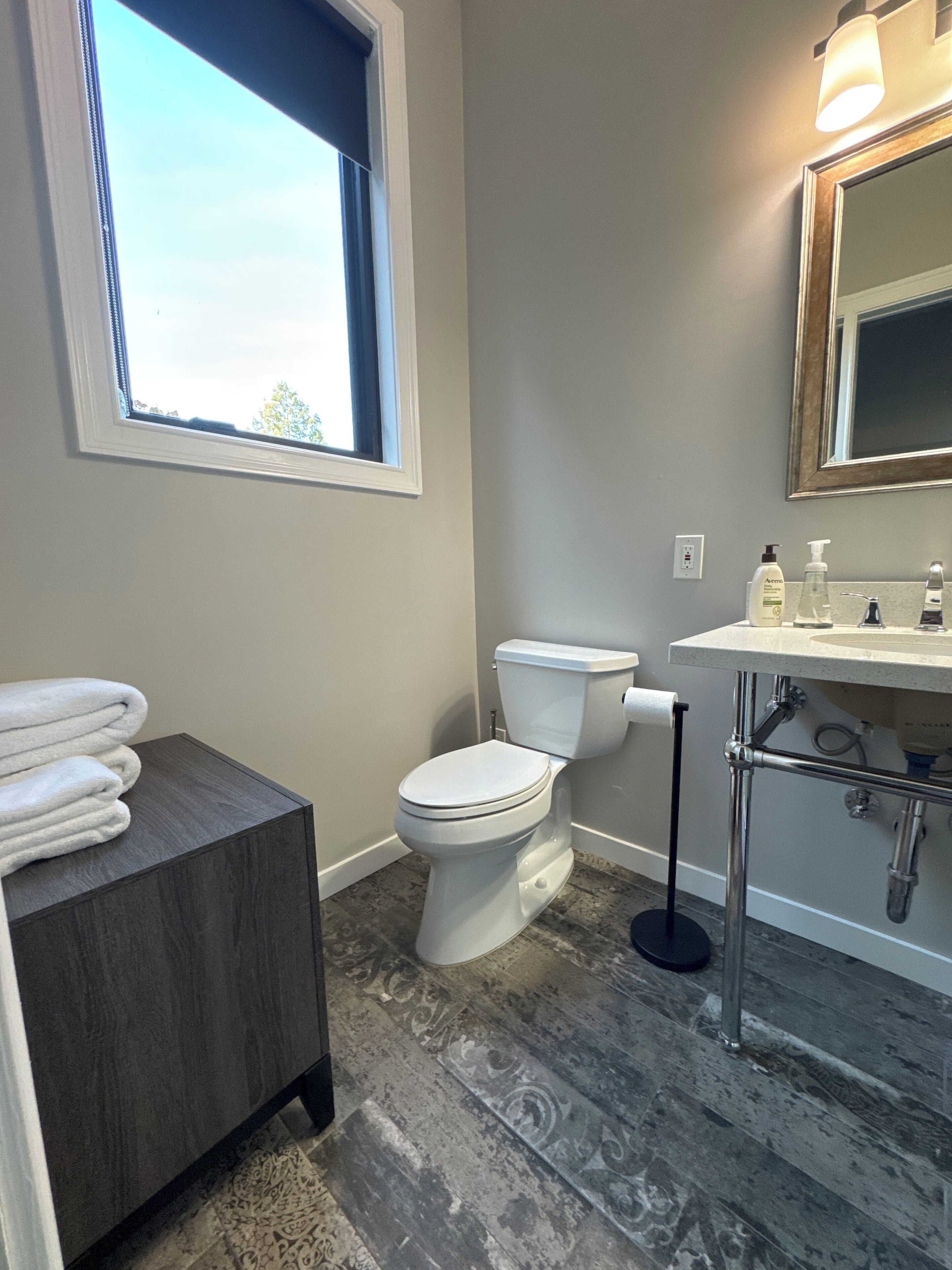 Ein Badezimmer mit Toilette, Waschbecken und Fenster.