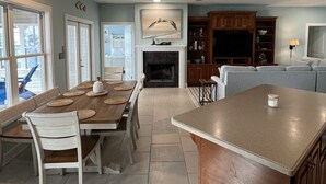 A spacious kitchen with a dining area, a fireplace, and a ceiling fan. - Bayfront home with private pier & dock- near Fairhope & Magnolia Springs (Foley)