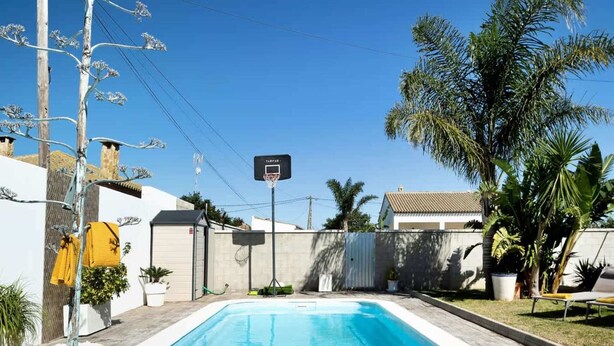 A rectangular swimming pool with a tiled edge, surrounded by a wooden deck. - Welcoming Villa With Private Pool (Conil de la Frontera)