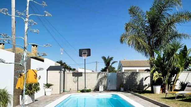 A rectangular swimming pool with a tiled edge, surrounded by a wooden deck. - Welcoming Villa With Private Pool (Conil de la Frontera)