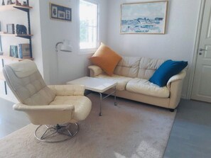 A living room with a beige sofa, a white armchair, a small white table, and a floor lamp. - 4 Star Holiday Home in Brosarp (Brosarp)