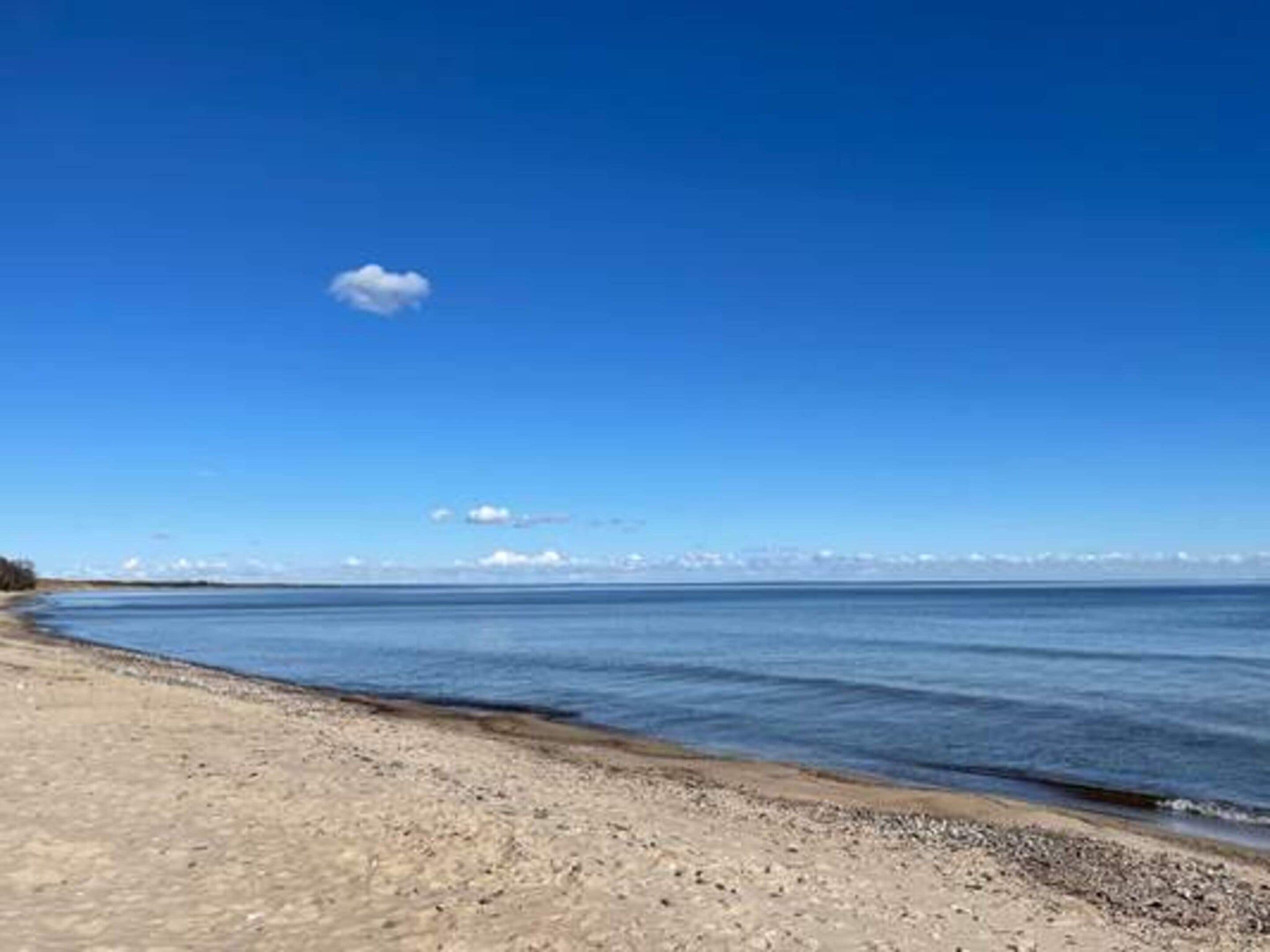 A beach with a clear sky and calm water.