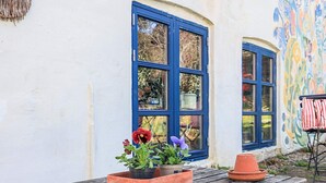 Een houten tafel in landelijke stijl met potplanten en een bank.