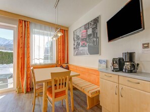A cozy room with a wooden bench, a table, and a coffee station. - Apartment in Tyrol in an Attractive Area (Fiss)