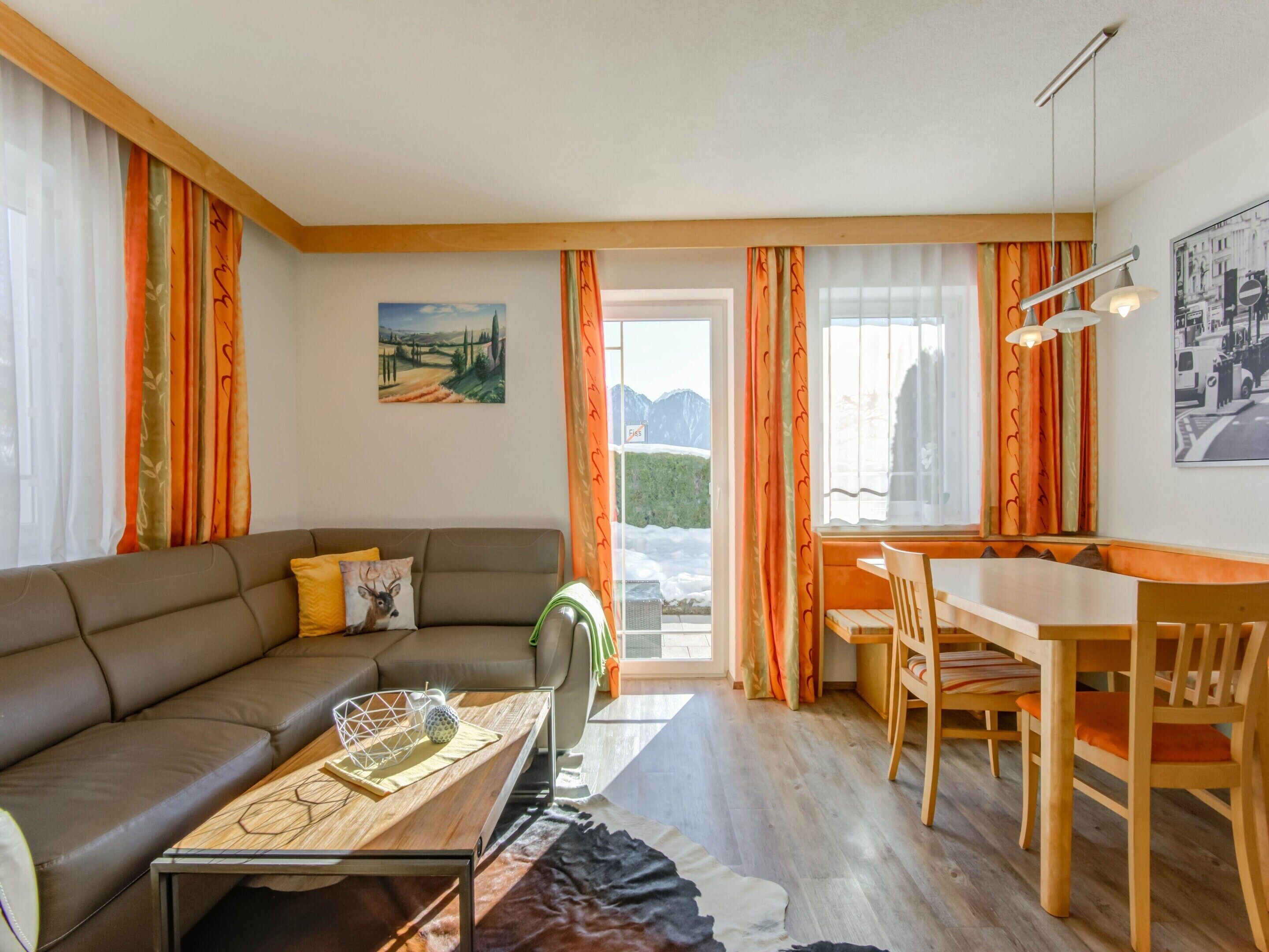 A cozy living room with a sofa, coffee table, and dining area.