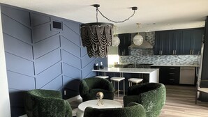 A modern kitchen with dark cabinets, a central island, and a hanging light fixture. - Open water 3bdrm 3bath home with dock for 20 foot boat along with pool & jacuzzi (St. Petersburg)