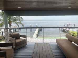 A covered outdoor seating area with a view of the sea and a dock. - Open water 3bdrm 3bath home with dock for 20 foot boat along with pool & jacuzzi (St. Petersburg)