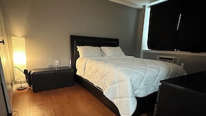 A bedroom with a bed, bedside tables, a lamp, and a TV. - Serene 2-bedroom apartment with AC in vibrant Bronx neighborhood (bronx)