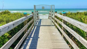 A wooden boardwalk leading to a gated entrance with a view of the ocean. - Walk to Rosemary, Resort Pool, Bikes, Beach Gear (Panama City Beach)
