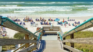 A wooden staircase leading to a beach with blue chairs and umbrellas. - Walk to Rosemary, Resort Pool, Bikes, Beach Gear (Panama City Beach)