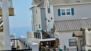 Zona residencial costera con varias casas, incluyendo una con balcón con vista al mar.