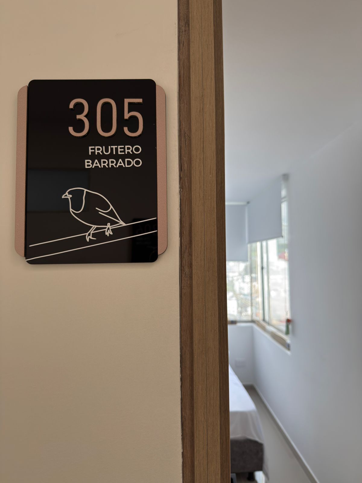 A sign with the number 305 and the text "FRUTERO BARRADO" on a wall.