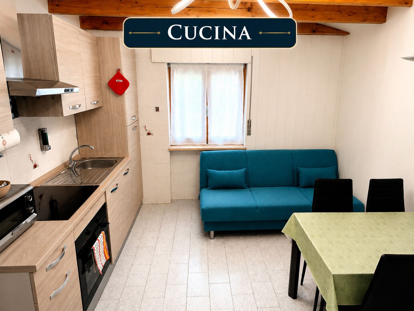 Una cucina compatta con lavandino, fornelli e un cartello con la scritta 'CUCINA'.
