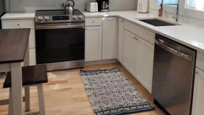 A modern kitchen with white cabinets, stainless steel appliances, a built-in oven, a microwave, and a dishwasher. - Entire House. 2+ bed, 2 bath near Lake & bikeway (Burlington)