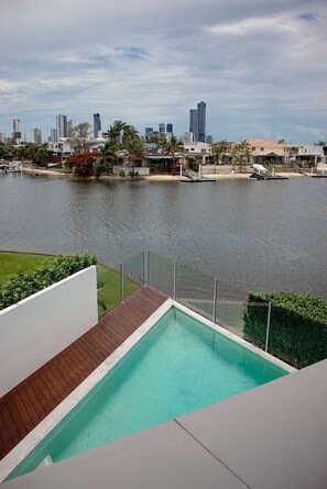 Una piscina moderna con un horizonte urbano de fondo.