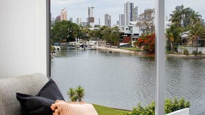 Ein modernes Wohnzimmer mit großem Fenster und Blick auf Stadt und Wasser.