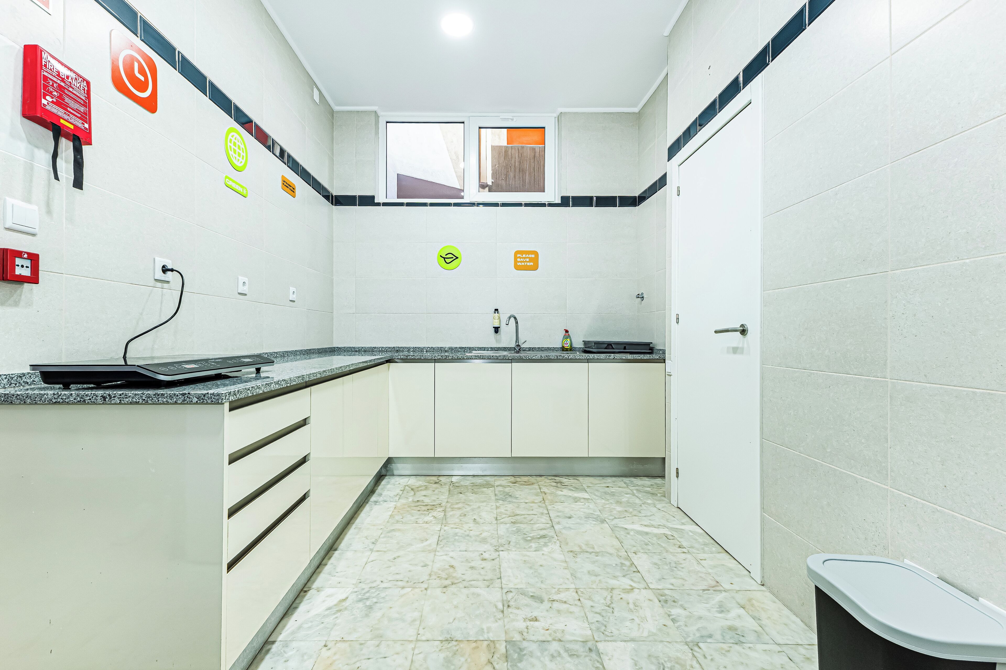 A modern kitchen with a granite countertop, white cabinets, and a tiled backsplash.